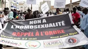 Protesters hold signs reading 'no to homosexuality' during a demonstration in Dakar