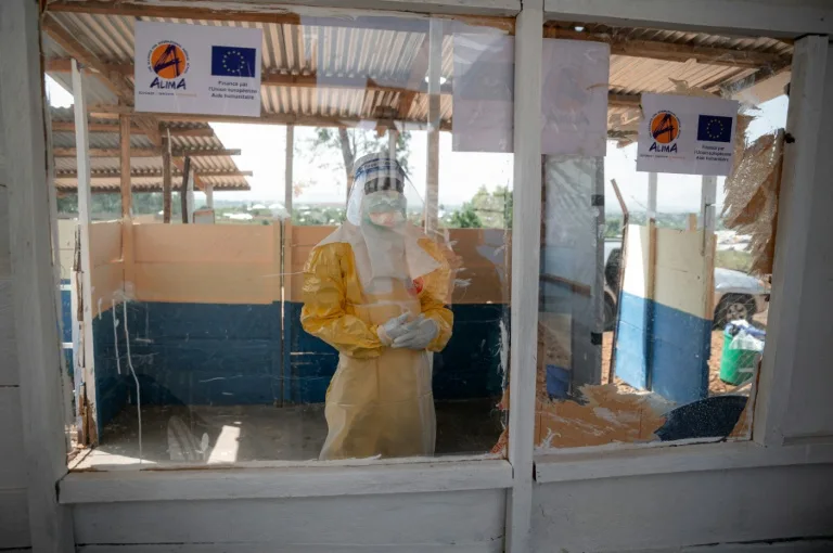 Health workers in protective gear attending to an Ebola patient in a treatment center